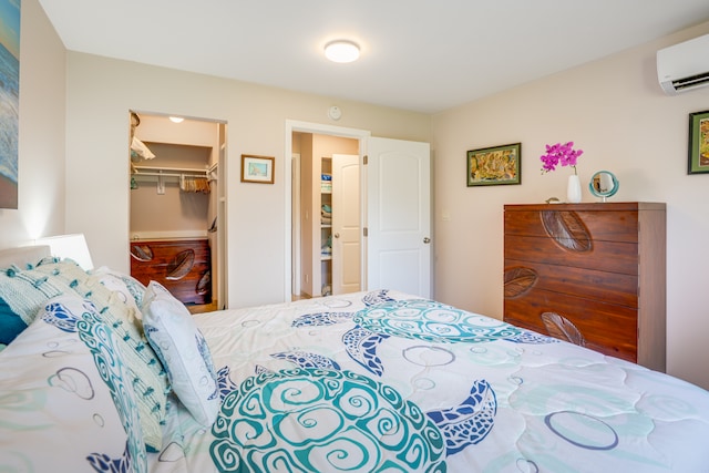 bedroom with a spacious closet, a closet, and a wall mounted AC