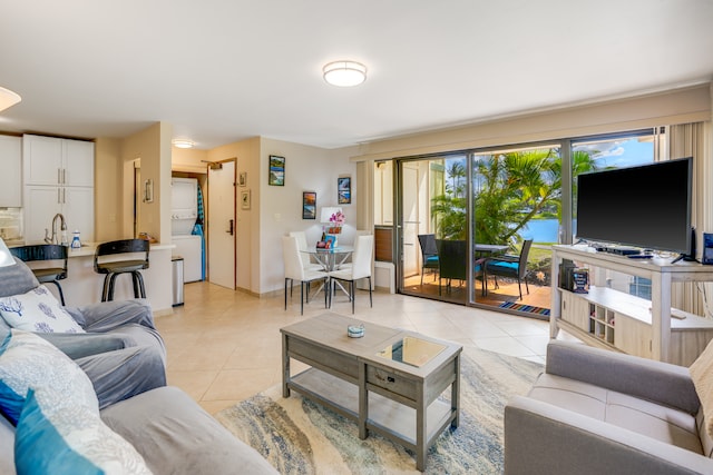 living room with stacked washer and dryer and light tile flooring