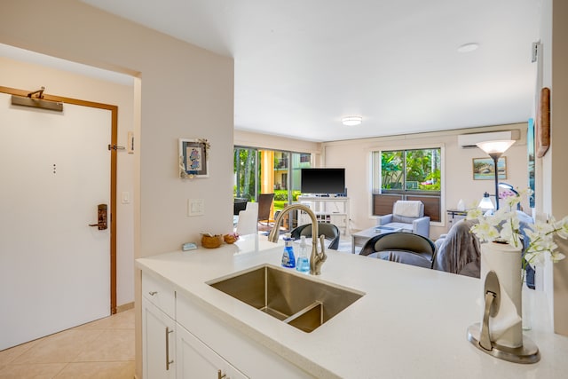 kitchen with sink, white cabinetry, and light tile floors