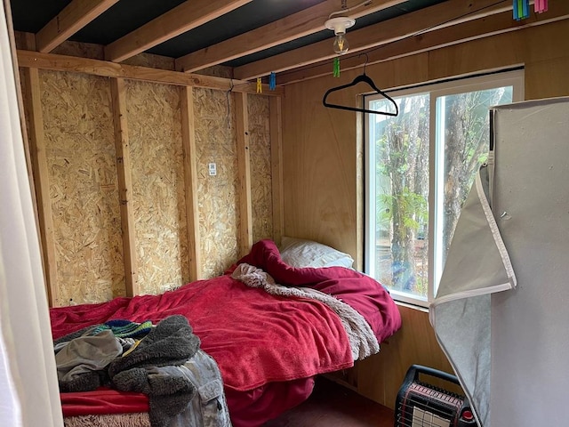 bedroom featuring wooden walls and multiple windows