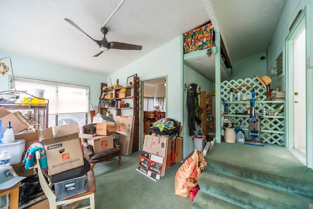 interior space featuring a textured ceiling, carpet floors, and ceiling fan