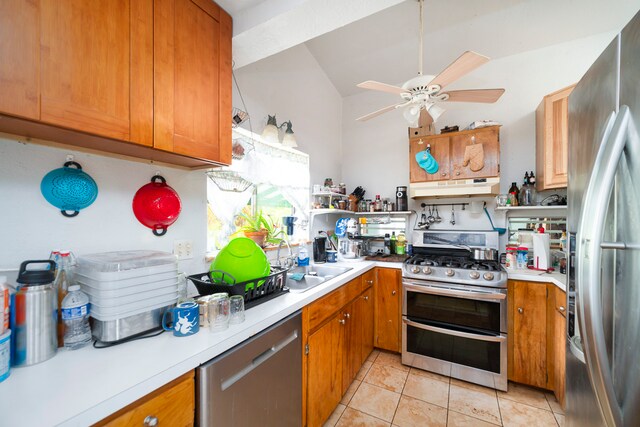 kitchen with appliances with stainless steel finishes, ceiling fan, light tile floors, sink, and lofted ceiling