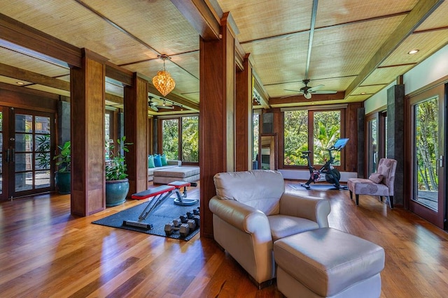 sunroom / solarium with wood ceiling, french doors, and ceiling fan with notable chandelier