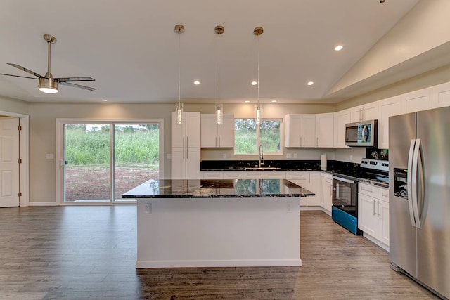 kitchen with white cabinets, appliances with stainless steel finishes, a kitchen island, and a wealth of natural light