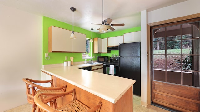 kitchen with white cabinetry, black appliances, light tile patterned flooring, ceiling fan, and hanging light fixtures