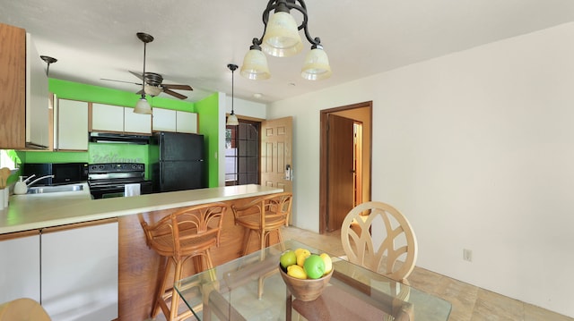 kitchen featuring black appliances, white cabinets, pendant lighting, range hood, and light tile patterned floors