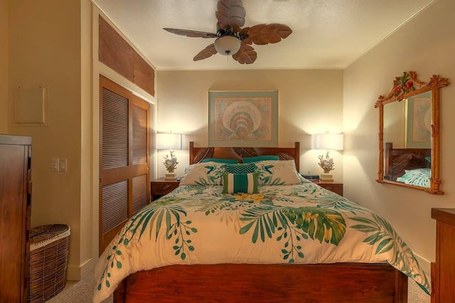 carpeted bedroom featuring crown molding, ceiling fan, and a closet