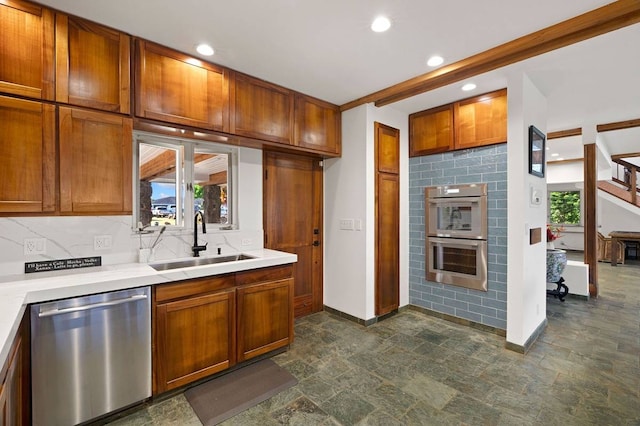 kitchen with sink, dark tile flooring, backsplash, and stainless steel appliances