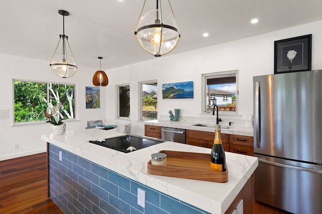 kitchen featuring sink, stainless steel appliances, light stone countertops, and dark wood-type flooring