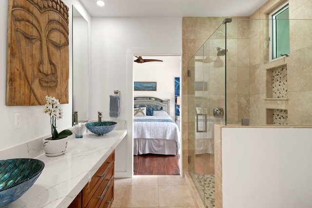 bathroom featuring a shower with door, tile flooring, and vanity