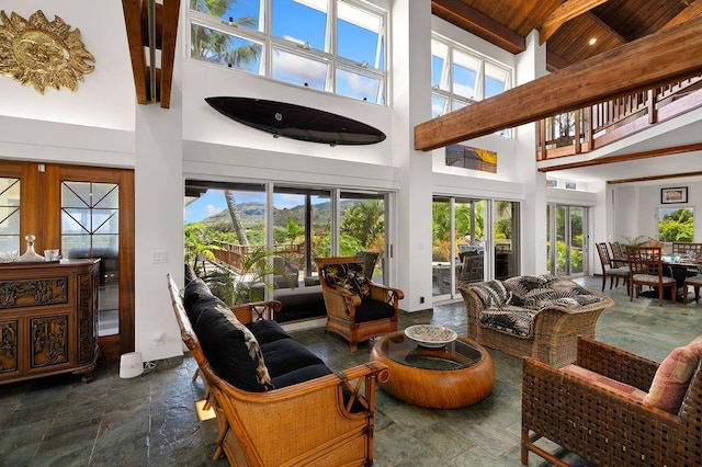 living room with wooden ceiling, a towering ceiling, and dark tile floors