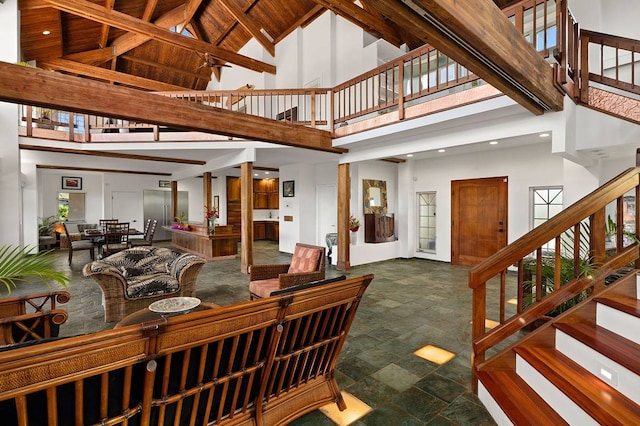 tiled living room featuring beamed ceiling and high vaulted ceiling