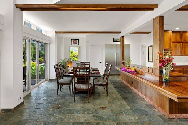 dining space with beam ceiling and dark tile floors