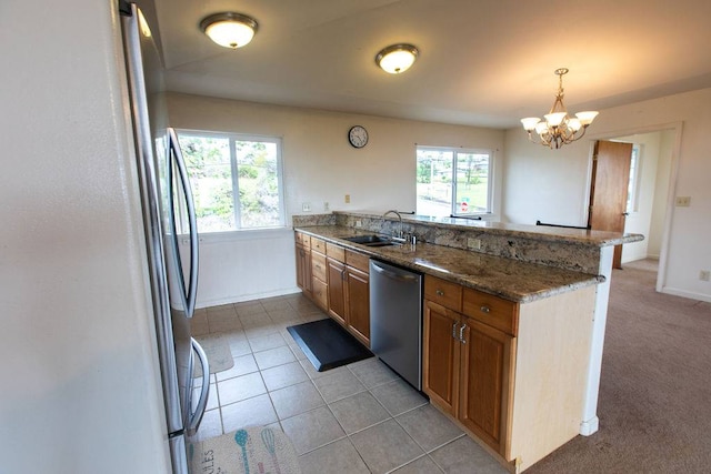 kitchen featuring appliances with stainless steel finishes, plenty of natural light, sink, and decorative light fixtures