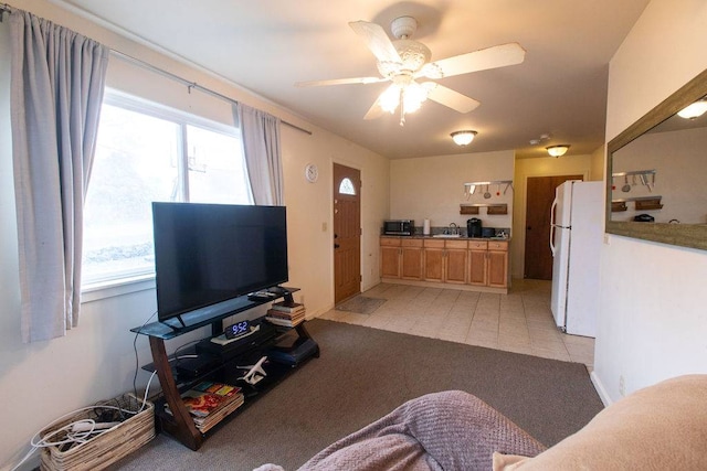 tiled living room with sink, ceiling fan, and a healthy amount of sunlight