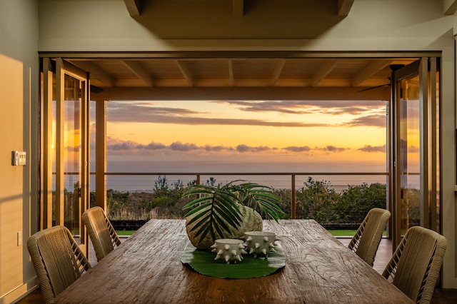 exterior space with beamed ceiling and a water view