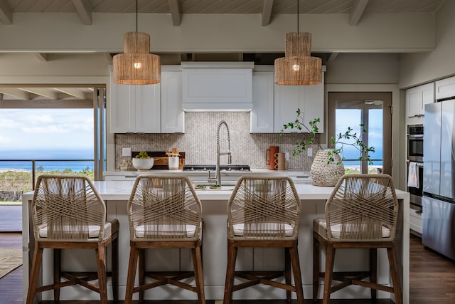 kitchen featuring beamed ceiling, white cabinets, and decorative backsplash