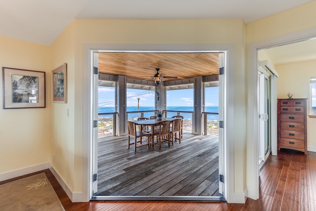 doorway to outside with a water view, dark hardwood / wood-style floors, and ceiling fan