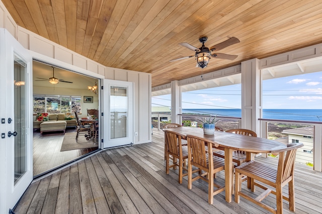 deck with ceiling fan and a water view