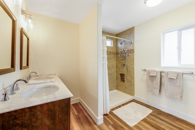 bathroom featuring double sink vanity, wood-type flooring, and a shower with shower curtain