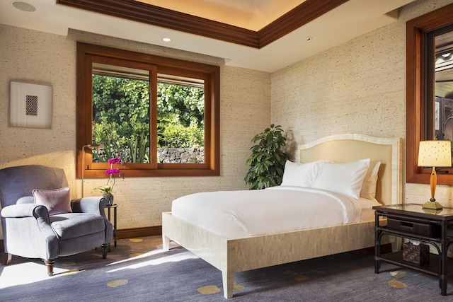 bedroom featuring a raised ceiling, crown molding, and carpet floors