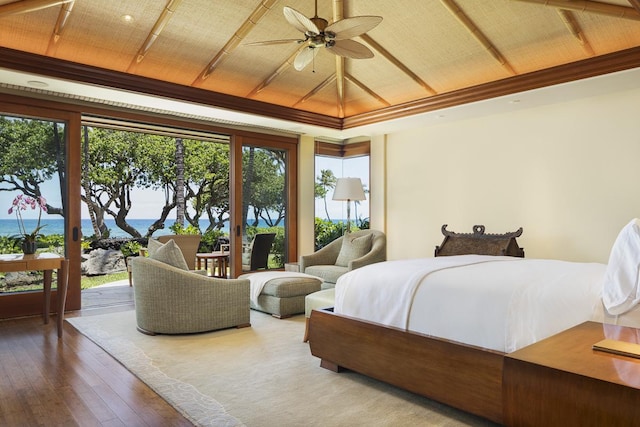 bedroom with hardwood / wood-style floors, ceiling fan, a water view, and multiple windows