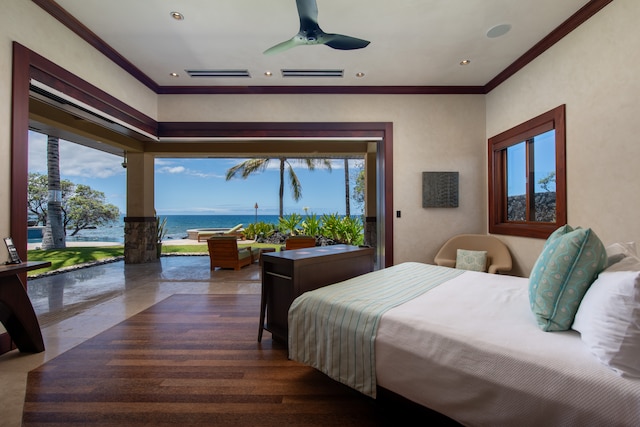 bedroom with dark wood-type flooring, a water view, ceiling fan, and multiple windows