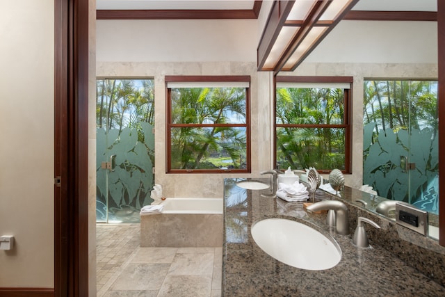 bathroom with a healthy amount of sunlight, tile flooring, and a relaxing tiled bath