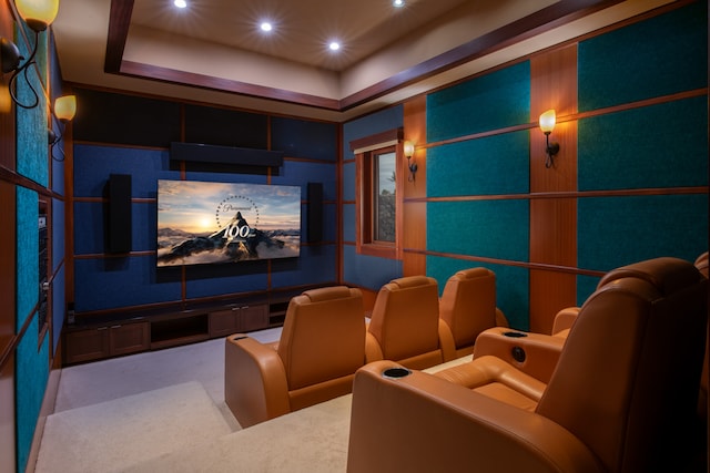 cinema featuring a tray ceiling and carpet flooring