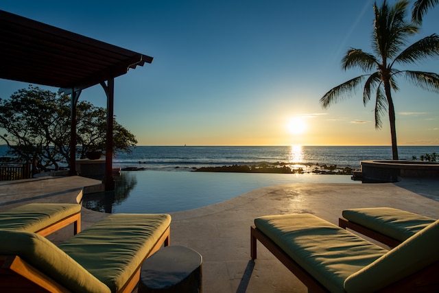 patio terrace at dusk with a water view and outdoor lounge area