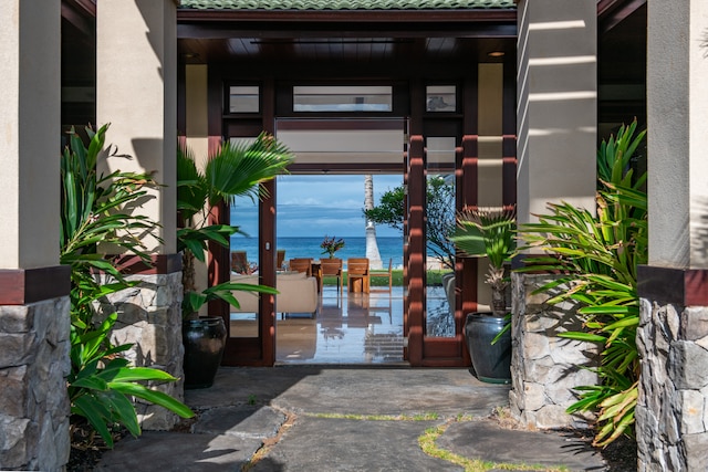 property entrance featuring a patio area and a water view