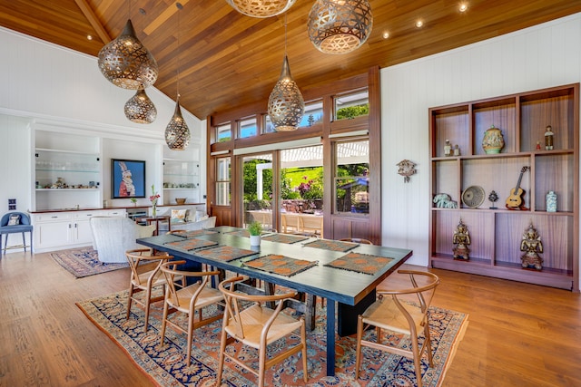 dining space featuring high vaulted ceiling, wooden walls, wooden ceiling, and light hardwood / wood-style floors