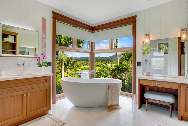 bathroom with vanity, tile patterned flooring, a bathtub, and a wealth of natural light