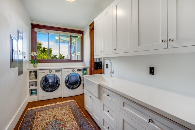 washroom featuring cabinets, sink, independent washer and dryer, and dark hardwood / wood-style floors