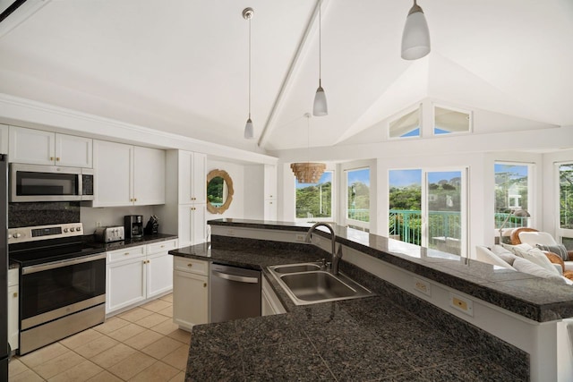 kitchen featuring a kitchen island with sink, plenty of natural light, appliances with stainless steel finishes, light tile floors, and sink