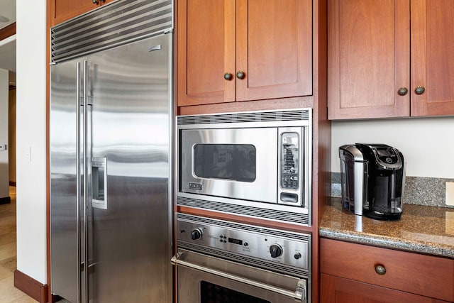 kitchen featuring stone counters and built in appliances