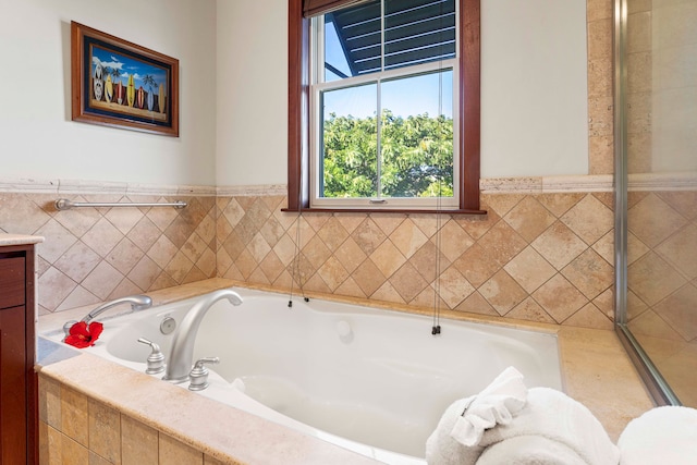 bathroom with a relaxing tiled bath and vanity