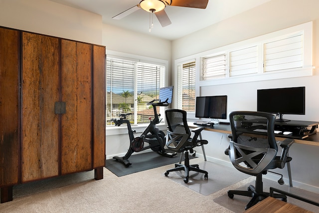 carpeted office space with ceiling fan