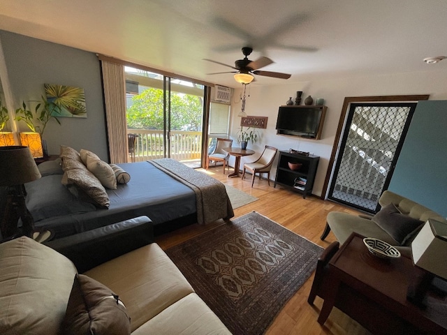 living room with hardwood / wood-style floors, ceiling fan, and a wall mounted AC