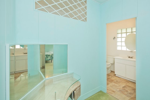 bathroom with tile flooring, vanity, and toilet