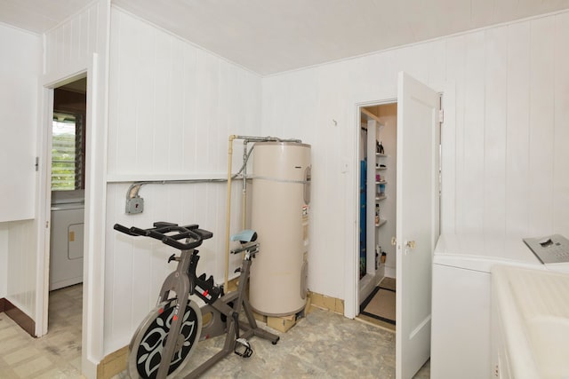 interior space with electric water heater, independent washer and dryer, and light tile floors