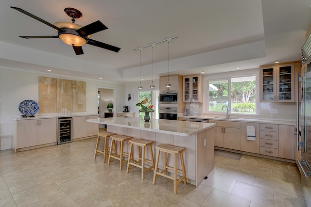 kitchen featuring a center island, hanging light fixtures, sink, ceiling fan, and track lighting