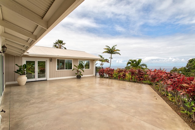 view of patio with french doors and a water view