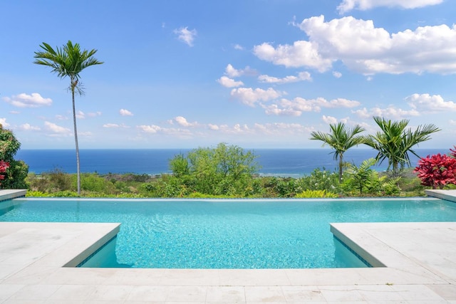 view of swimming pool with a patio and a water view