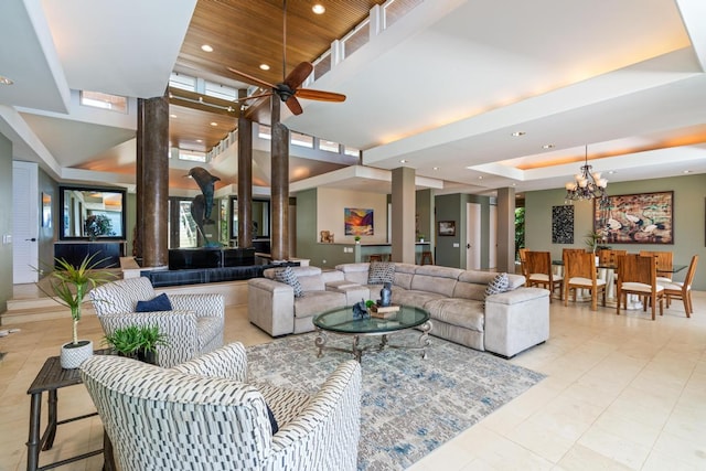 tiled living room featuring ceiling fan with notable chandelier and a tray ceiling