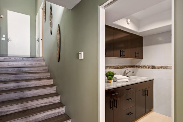 stairway with sink and tile walls