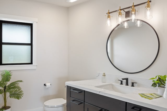 bathroom with a wealth of natural light, vanity, and toilet