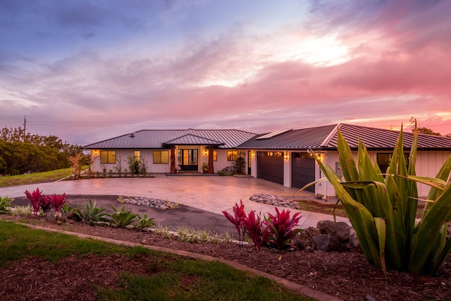 back house at dusk featuring a garage