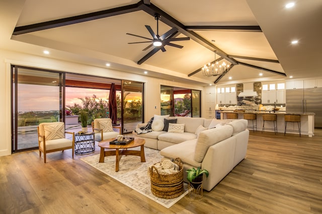 living room featuring beam ceiling, ceiling fan with notable chandelier, and hardwood / wood-style flooring