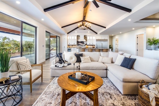 living room with a notable chandelier, hardwood / wood-style floors, and lofted ceiling with beams